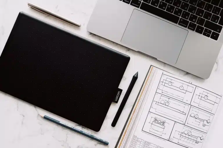 Poste de travail créatif avec ordinateur portable et outils de design.