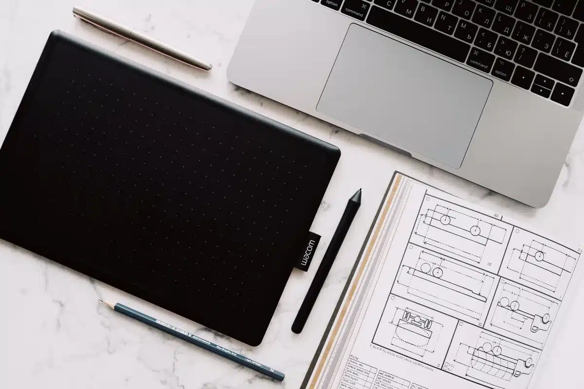 Poste de travail créatif avec ordinateur portable et outils de design.