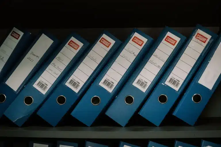 Dossiers et documents classés dans des boîtes d'archives.