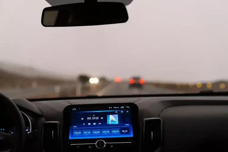 Vue du tableau de bord d'une voiture sur une route dégagée.