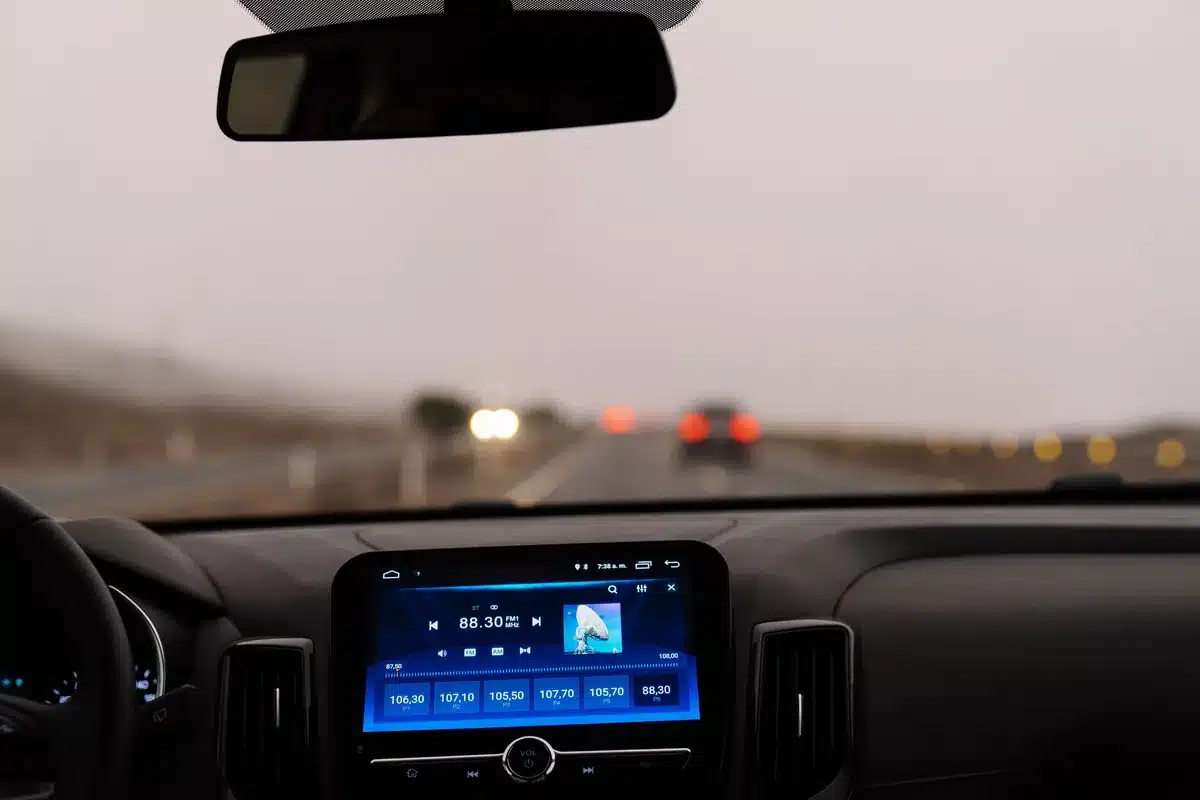 Vue du tableau de bord d'une voiture sur une route dégagée.