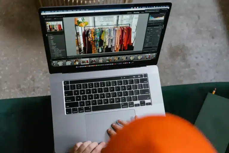 Une personne prépare des visuels de produits sur un ordinateur portable pour les vendre en ligne.