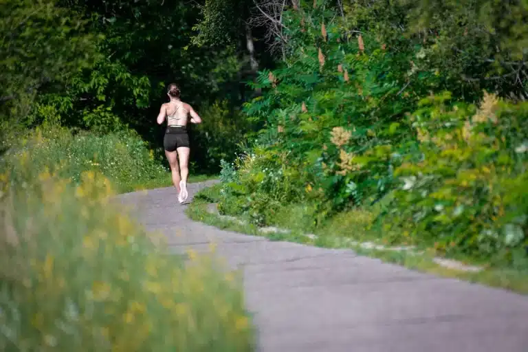 Une personne court sur un sentier en pleine nature.