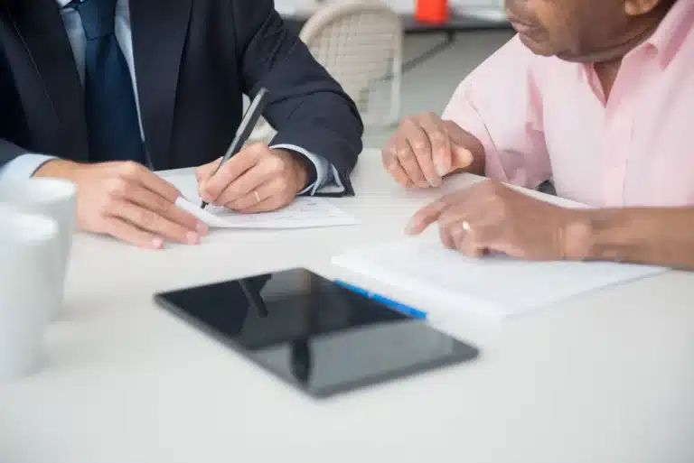 Personne signant un document sur une tablette.